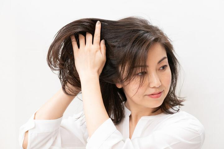 ワックスを両手のひらに広げ髪を揉み込むようにしてなじませる。