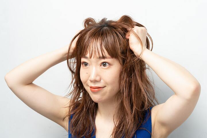 空気を含ませるように、髪の内側、毛先を中心に揉み込む。バームやクリーム系のワックスなど、なめらかなテクスチャーのスタイリング剤を使って。