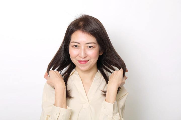 シアバターを手のひらにのばし、内側からなじませる。髪を下に引っ張らず、外に弧を描くイメージでふんわりと仕上げて。