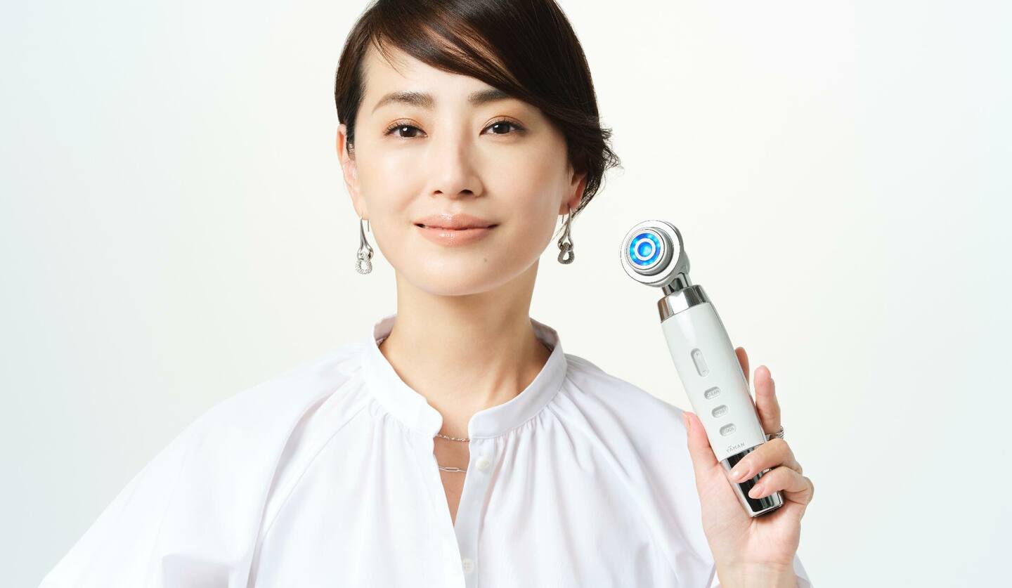 美顔器を手に持つ女性